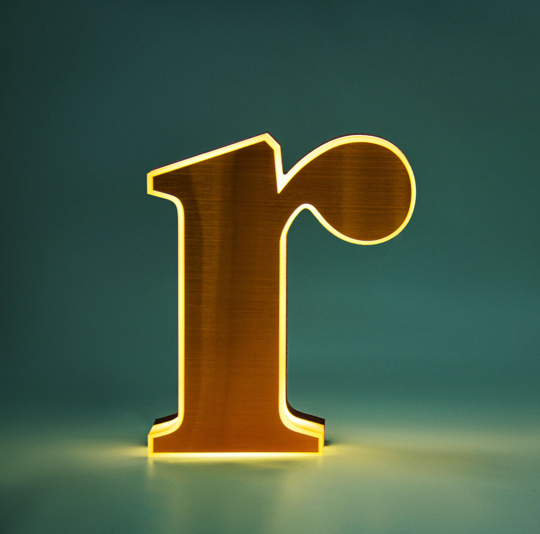 Litera R - świecąca bokiem w kolorze złotym na zielonym tle